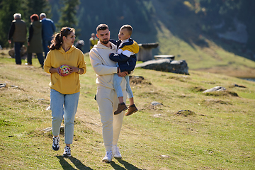 Image showing A modern family, along with their son, revels in the joy of a muddy day in nature, running and playing together, encapsulating the beauty of a healthy and active lifestyle