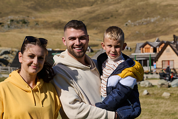 Image showing A modern family, along with their son, revels in the joy of a muddy day in nature, running and playing together, encapsulating the beauty of a healthy and active lifestyle