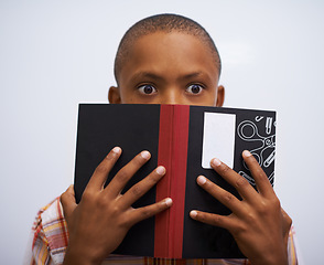 Image showing Student, classroom and hide face with book to read in front for classmates, shy and nervous. Elementary school, boy and prepared oral with workbook, childhood development and academic education