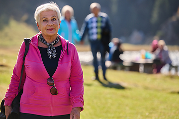 Image showing A senior woman finds serenity and wellness as she strolls through nature, illustrating the beauty of maintaining an active and health-conscious lifestyle in her golden years