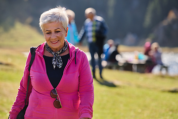 Image showing A senior woman finds serenity and wellness as she strolls through nature, illustrating the beauty of maintaining an active and health-conscious lifestyle in her golden years