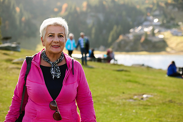 Image showing A senior woman finds serenity and wellness as she strolls through nature, illustrating the beauty of maintaining an active and health-conscious lifestyle in her golden years