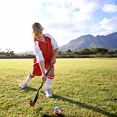 Image showing Girl, green grass and playing hockey for game, outdoor match or sports in nature for practice. Female person, kid or playful child enjoying competition with ball on field for fitness or training