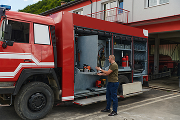 Image showing A dedicated firefighter preparing a modern firetruck for deployment to hazardous fire-stricken areas, demonstrating readiness and commitment to emergency response