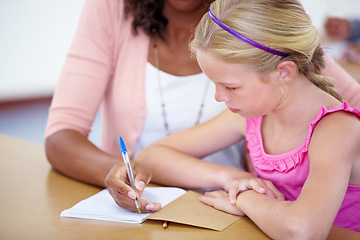 Image showing Child, girl and student with teacher and writing in classroom, learning and helping for assessment or exam. Study, knowledge and education, people with notebook and pen for notes and info in class