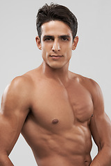 Image showing Man, shirtless and portrait or bodybuilder pride in studio, abs and fitness by gray background. Male person, confident and strong core or muscular abdomen, face and results or progress from exercise