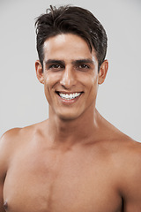 Image showing Man, portrait and smile for skincare in studio, cosmetology and glow by gray background or shine. Male person, face and happy for beauty and dermatology, care and satisfaction in facial treatment