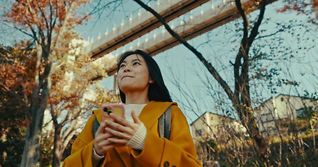 Image showing Japanese woman, city and phone for technology in fashion, weekend and digital connection in urban area. Young person, smile or trendy clothes for trip on holiday adventure, tokyo town or smartphone