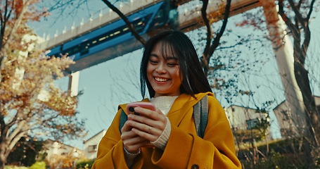 Image showing Japanese woman on street with phone, typing and reading online chat on morning commute. Search, schedule and travel, Asian girl in city checking email or post on smartphone app on journey in Tokyo.