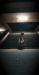 Image showing Dancing, night and woman with ballet, training and artistic with performance, light and talent. Person, dancer and girl with workout, culture and practice with routine, staircase and ballerina