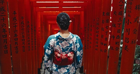 Image showing Woman, shinto religion or back by gates in japan, spiritual path or indigenous culture in kimono. Person, traditional clothes or worship in peace, respect or heritage by Fushimi Inari Taisha in kyoto