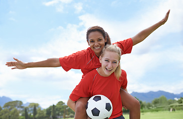 Image showing Happy woman, friends and piggyback for outdoor soccer on green grass in winning, achievement or sport in nature. Portrait of female person or football player smile for match, game or victory on field