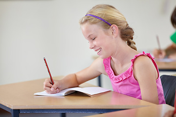 Image showing School, girl and smile for writing in classroom, studying lesson or learning assessment at desk. Child, student or happy kid drawing in notebook of academic development, educational test or knowledge
