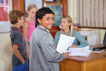 Image showing Teacher, portrait or happy kid with paper in classroom for education, learning or tutoring at school. Boy, smile or educator helping a group of young students or children with paperwork for studying