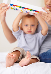 Image showing Abacus, portrait and baby with mother playing, learning and teaching for child development on bed. Bonding, toy and mom teaching kid, infant or toddler math counting in bedroom at modern home.