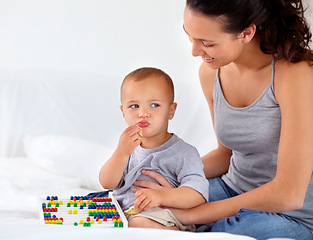 Image showing Abacus, relax and baby with mother playing, learning and teaching for child development on bed. Bonding, toy and closeup of mom teaching kid, infant or toddler with counting in bedroom at home.