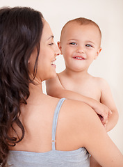 Image showing Family, happy and mother with child on a white background for bonding, relationship and relax together. Love, youth and portrait of mom carrying kid for growth, playing and development in studio