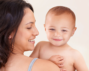 Image showing Family, love and mother with baby on a white background for bonding, relationship and relax together. Happy, youth and mom carrying kid for childcare wellness, playing and development in studio