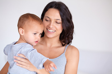 Image showing Mom holding toddler in home with smile, bonding and child care with support in morning. Happy woman, baby boy and spending time together in bedroom with development, trust and safety in mothers love.