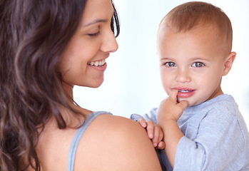 Image showing Family, happy and mother with baby on a white background for bonding, relationship and relax together. Love, youth and portrait of mom carrying kid for growth, playing and child development in studio