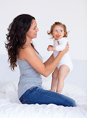 Image showing Bonding, sweet and mother playing with baby on bed in morning together at family home. Happy, smile and young mom having fun with girl infant, kid or toddler for child development in bedroom at house