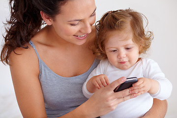 Image showing Cellphone, playing and mother with baby on bed for bonding and watching video on social media together. Happy, love and young mom scroll on a phone with girl child, kid or toddler in bedroom at home