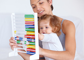 Image showing Abacus, playing and girl baby with mother for math, learning and teaching for child development on bed. Bonding, toy and young mom with kid, infant or toddler with counting in bedroom at home.