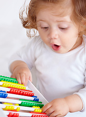Image showing Abacus, surprise and girl baby learning, playing and teaching for child development on bed. Maths, toy and closeup of young kid, infant or toddler counting for education in bedroom at modern home.