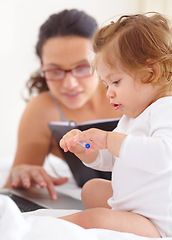 Image showing Mom, working and multitasking on laptop with baby in home for remote work or writing project. Infant, kid and mother busy with freelance productivity on computer and child in bedroom playing with pen