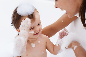 Image showing Baby, bath and mother laughing in a bathroom with cleaning, foam and help with love and support. Care, mom and young child with soap in a home with bonding and washing for wellness and hygiene