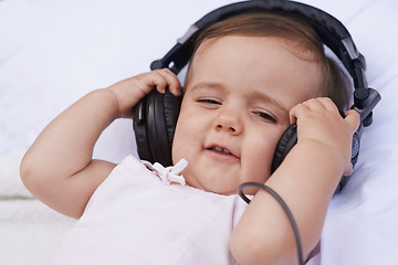 Image showing Baby, headphones and listening to music for fun, streaming radio and podcast on bed at home. Child, relax and hearing sound for child development or learning, toddler and calming playlist for audio