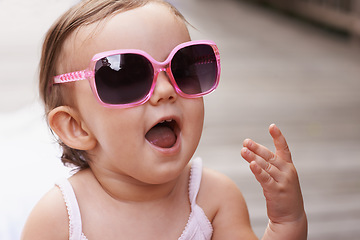 Image showing Baby, laugh and sunglasses outdoor with summer, youth fashion and young girl on holiday. Kid, fun frames and happy on vacation with shades style, child clothes and trendy accessory of toddler
