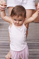 Image showing Mother, outdoors and baby learning to walk, support and teaching toddler for child development or growth. Mommy, girl and trust in parent and childcare, security and education for skills on deck