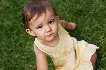 Image showing Cute, grass and portrait of girl baby having fun and playing in backyard, park or garden. Nature, sweet and kid, infant or toddler sitting on the lawn for child development senses outdoor at home.