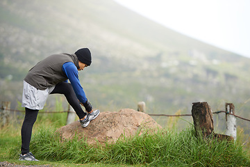 Image showing Man, tie lace for running and fitness outdoor, mountain and nature with runner and sneakers to start exercise. Workout, training and shoes in road, ready for race or cardio with endurance for health