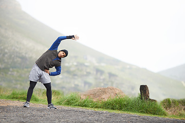 Image showing Man, stretching and start fitness outdoor, mountain and nature with runner and exercise. Workout, training and warm up in road, ready for race or cardio with endurance for health, running and sports