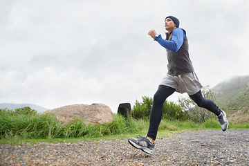 Image showing Trail, runner and man running in nature training, cardio exercise and endurance workout for wellness. Sports, fitness or healthy male athlete on fast jog on mountain outdoors with speed of action