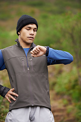 Image showing Man, hiking and check time for adventure, earphones and face for music, exercise and workout. Hiker, fitness and watch for training, forest and nature to explore, hobby and heart health in outdoors