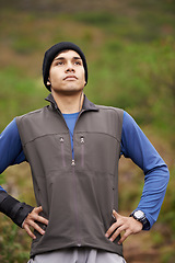 Image showing Man, hiker and thinking for adventure, earphones and listening to podcast, exercise and workout. Hiking, fitness and climber for training, forest and nature to explore, hobby and health in outdoors