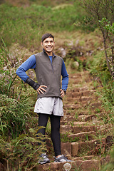 Image showing Man, hiking and happy for adventure, trail and face for mountain, exercise and workout. Hiker, fitness and climber for training, forest and nature to explore, hobby and heart health in outdoors