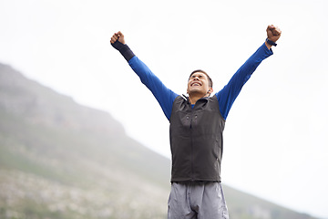 Image showing Man, hiker and winner on mountain peak and happy with progress, exercise and victory. Hiking, fitness and climber for training, achievement and nature to explore, success and health in outdoors