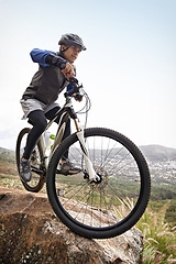 Image showing Man, mountain bike and off road cycling in fitness for nature adventure or outdoor extreme sport. Male person or cyclist on bicycle for cardio, dirt path or speed on cliff in exercise with blue sky