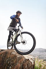 Image showing Man, mountain bike and off road cycling on nature adventure or fitness in outdoor extreme sport. Male person or cyclist on bicycle for cardio or dirt path terrain on cliff for exercise with blue sky