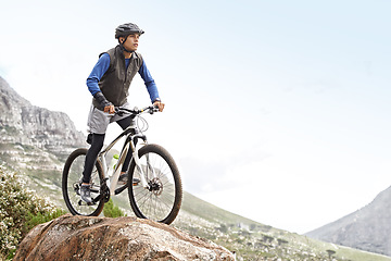 Image showing Man, mountain bike and off road cycling with mockup space on nature adventure or fitness in outdoor extreme sport. Male person or cyclist on bicycle for cardio on cliff hill in exercise with blue sky