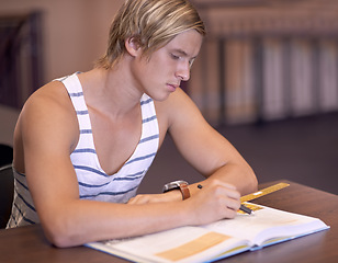 Image showing Education, university and man in library with books for studying, learning and research with knowledge. Writing, college and male student with textbooks for assignment, project and test on campus