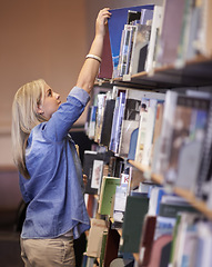 Image showing Student woman, library and search bookshelf for studying, learning and scholarship with development at campus. Girl, research and books on shelf for information, knowledge and thinking at university