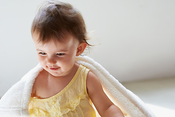 Image showing Baby, blanket and playing on floor, child development and infant growth with face, sitting and home. Girl, joyful and healthy in good mood, childhood and cheerful with enthusiasm, kid and adorable