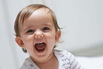 Image showing Baby girl, funny and happy for playing, child development and infant growth with face, sitting and home. Laugh, joyful and healthy in good mood, childhood or cheerful with enthusiasm, kid or adorable