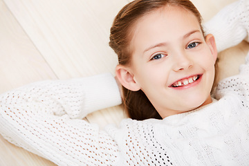 Image showing Child, portrait and smile on floor for youth holiday or relax at home, cool outfit or vacation. Female person, face and happy kid for peaceful rest or casual style for confidence on weekend above