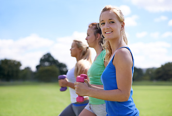 Image showing Girl, group with dumbbells and weightlifting for fitness and muscle, strong athlete outdoor for sports on field. Portrait, exercise equipment in park and team workout together, endurance and strength